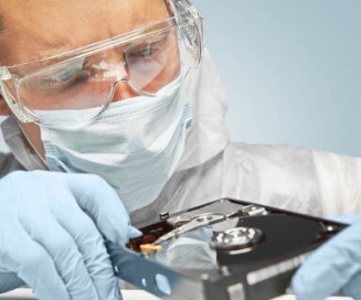 A laboratory worker examining a hard drive.