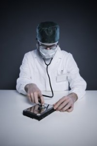 technician wearing a lab coat and stethoscope examining an hard disk